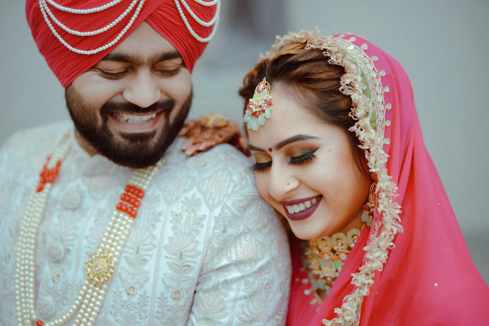A smiling bride and groom in pastel wedding outfits